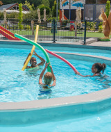 Des enfants jouent avec des frites de piscine colorées à Vakantiepark Ackersate, Gelderland, Pays-Bas.