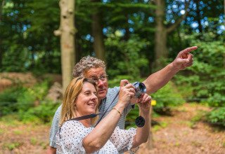 Couple takes photos in the forest at Vakantiepark Ackersate, Gelderland, Netherlands, enjoying nature.