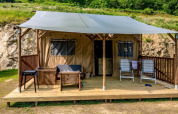 Safari teltet Lodgetent med sanitære faciliteter ved Camping l'Ardechois i Frankrig, med træterrasse og loungemøbler