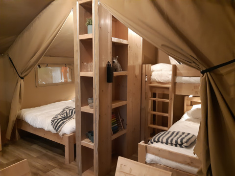 Innenaufnahme eines Safari-Zeltes auf Camping Le Bois de la Gachère in Frankreich mit komfortablen Betten.