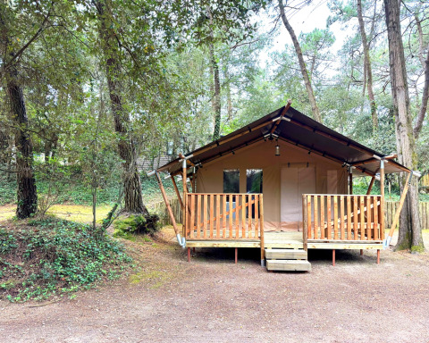 Safari-Zelt mit Holzterrasse im Wald beim Camping Le Bois de la Gachère in Frankreich.
