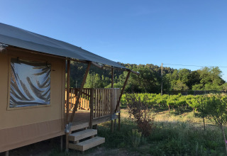 Safari telt med veranda og sanitære faciliteter på Camping De l'Olivigne, omgivet af vinmarker i Frankrig.