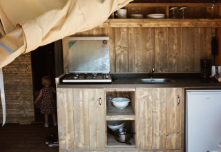 Binnenzicht van safaritent met keuken en sanitair op Camping Saint Amand in Frankrijk.