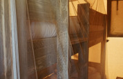 Bunk beds covered with mosquito netting inside a safari tent, softly illuminated in a cozy atmosphere.