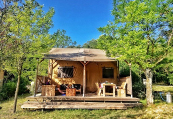 Safari Lodge-telt på Campsite Monti del Sole, Italien, omgivet af træer og solskin, afslappende udendørs.