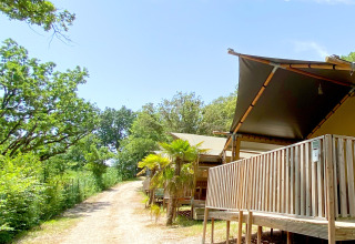 Tenda safari al campeggio Mar y Sierra in Italia, con terrazza in legno e immersa nel verde.