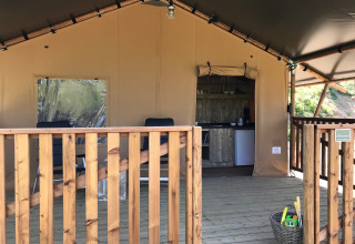 Safari-telt med træterrasse, køkken og legetøjskurv hos Agriturismo Le Sorgive e Le Volpi i Italien.
