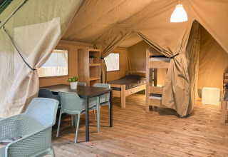 Indretning af safaritelt på Hvalpsund Familie Camping i Danmark med køjesenge og spisebord.