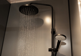 Moderne Dusche in einer Lodge mit großem Regenduschkopf und Handbrause in stilvollem, dunklem Badezimmer.