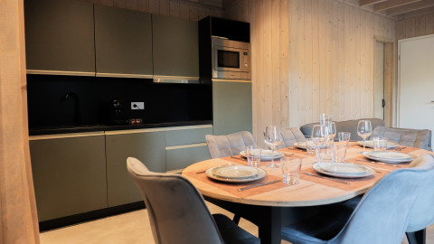 Modern kitchen and dining table set for six at Ecolodge l 2 Slaapkamers, Hameau de la Semois, Belgium.