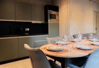 Modern kitchen and dining table set for six at Ecolodge l 2 Slaapkamers, Hameau de la Semois, Belgium.