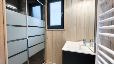 Modern bathroom with shower, wood paneling, window, and sink at Ecolodge l 2 Slaapkamers in Hameau de la Semois