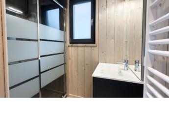 Moderne badkamer met douche, houten wanden en wastafel in Ecolodge l 2 Slaapkamers in Hameau de la Semois