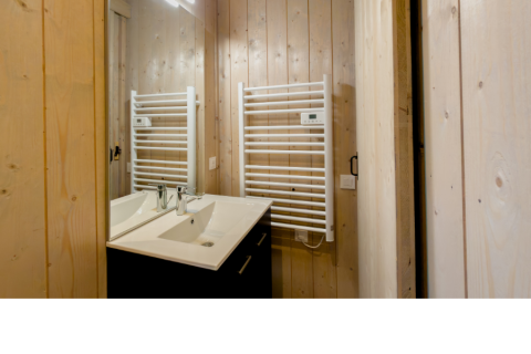 Badezimmer mit Doppelwaschbecken, Holzvertäfelung und weißem Handtuchheizkörper im Ecolodge l 2 Slaapkamers.