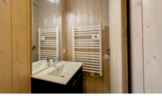 Badezimmer mit Doppelwaschbecken, Holzvertäfelung und weißem Handtuchheizkörper im Ecolodge l 2 Slaapkamers.