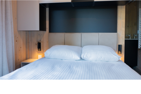 Modern bed with white linens and two pillows in Ecolodge l 2 Slaapkamers, Hameau de la Semois, Belgium.