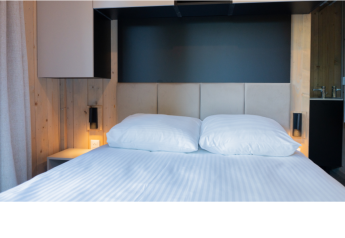 Modernes Bett mit weißer Bettwäsche und zwei Kissen im Ecolodge l 2 Slaapkamers, Hameau de la Semois, Belgien.