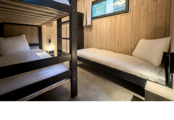 Zimmer mit Etagenbett und Einzelbett im Ecolodge l 2 Slaapkamers, Hameau de la Semois, Belgien.