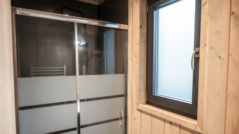Badkamer met douche en houten raam bij Ecolodge, Hameau de la Semois in België.