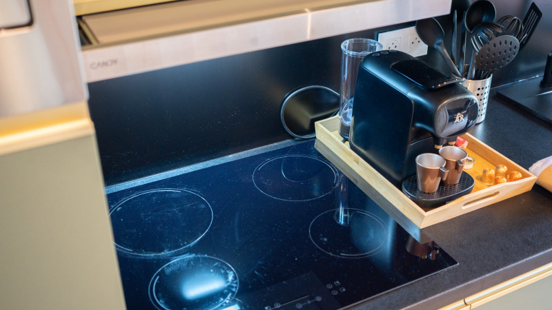 Keukentje met inductiekookplaat en koffiemachine in Ecolodge bij het Hameau de l'Ourthe, België.