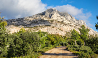 Wandelpad door groene begroeiing met uitzicht op de berg Sainte-Victoire nabij Aix-en-Provence.