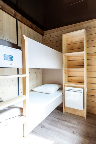 Et lyst, moderne værelse i Evasion Chalet med køjeseng, trævægge og hylder på Camping d'Aix en Provence.