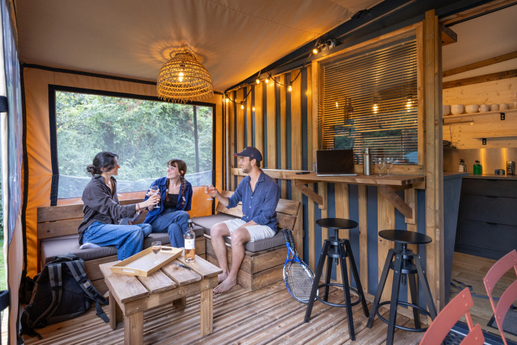 Tre personer nyder en afslappet aften i en hyggelig hytte ved Camping d'Aix en Provence, Frankrig.