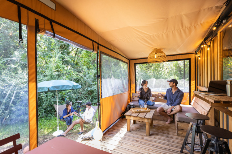 Innenansicht einer modernen Arizona-Hütte beim Camping d'Aix en Provence, Frankreich, mit entspannten Gästen.