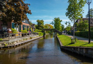 Photo du canal près du Vakantiechalet comfort+ au Vakantiepark De Wiedense Meren, Pays-Bas, par une journée ensoleillée.