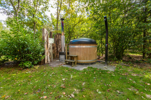 Buitenbad en douche bij Bosrand Wellness Cabin Premium in Vakantiepark De Wiltzangh, Nederland.