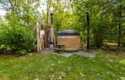Buitenjacuzzi en douche bij Bosrand Wellness Cabin Premium in Vakantiepark De Wiltzangh, Nederland.