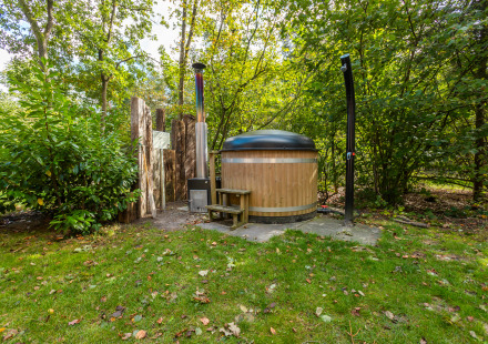 Buitenbad en douche bij Bosrand Wellness Cabin Premium in Vakantiepark De Wiltzangh, Nederland.