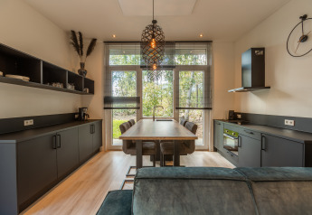 Cucina moderna e zona pranzo compatta nella Bosrand Wellness Cabin Premium al Vakantiepark De Wiltzangh.