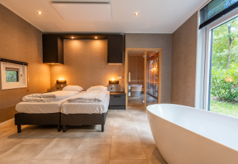 Bosrand Wellness Cabin Premium met twee bedden en vrijstaand bad bij De Wiltzangh, Nederland.