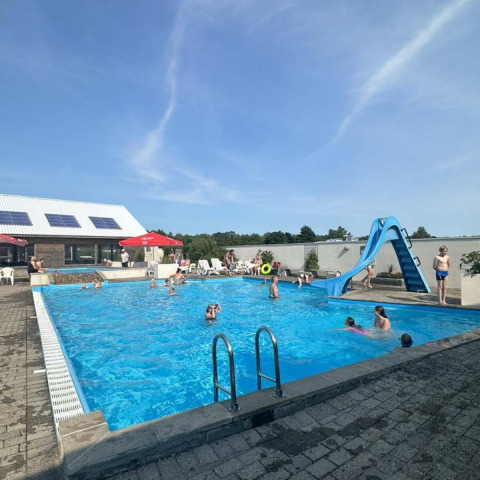 Piscine extérieure avec toboggan aquatique et vacanciers à Hvalpsund Familie Camping, Jutland du Nord, Danemark.