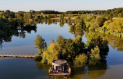 Vista aerea di una cabina sul lago circondata da alberi al Domaine des Feuilles, Auvergne-Rhône-Alpes, Francia.