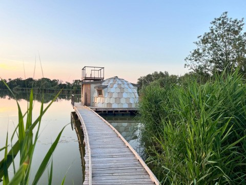 Cabane flottante en forme de dôme sur un lac à Domaine des Feuilles, Auvergne-Rhône-Alpes, France.