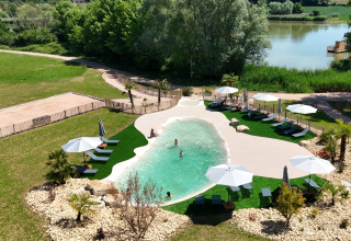 Swimming pool and lounge area at Domaine des Feuilles holiday park in Auvergne-Rhône-Alpes, France.
