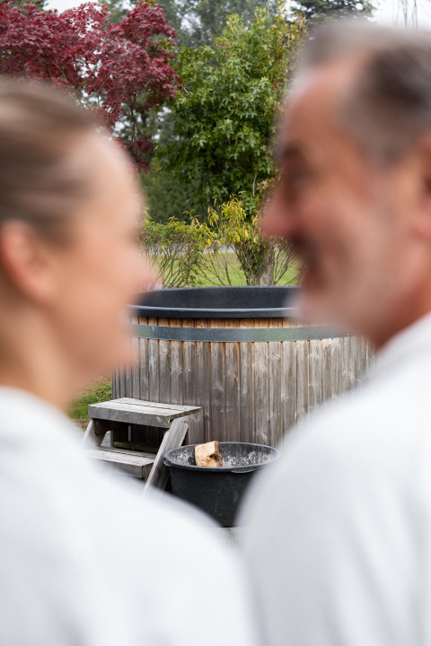 Blurred couple in white robes enjoying the private sauna and hot tub at ‘t Schuttenbelt in the Netherlands.