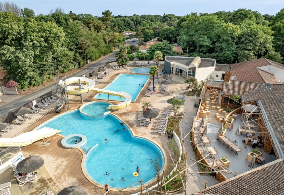 Vue aérienne de la piscine avec toboggans et transats au Flower Camping Au Bois Des Biches, Pays de la Loire.