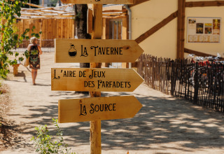 Houten wegwijzers in een vakantiepark in Pays de la Loire, Frankrijk, met richtingaanwijzingen.