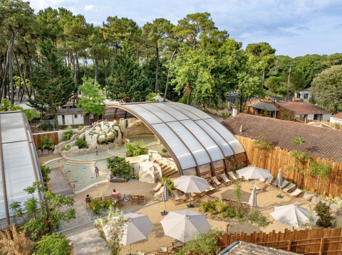 Luftaufnahme vom Flower Camping Au Bois Des Biches mit überdachtem Pool und Liegestühlen in Pays de la Loire.