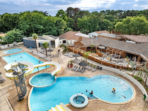 Vista aerea della piscina con scivolo d’acqua a Flower Camping Au Bois Des Biches, Pays de la Loire, Francia.