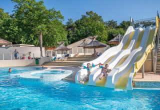 Des enfants s'amusent sur les toboggans de la piscine au Flower Camping Au Bois Des Biches, Pays de la Loire.