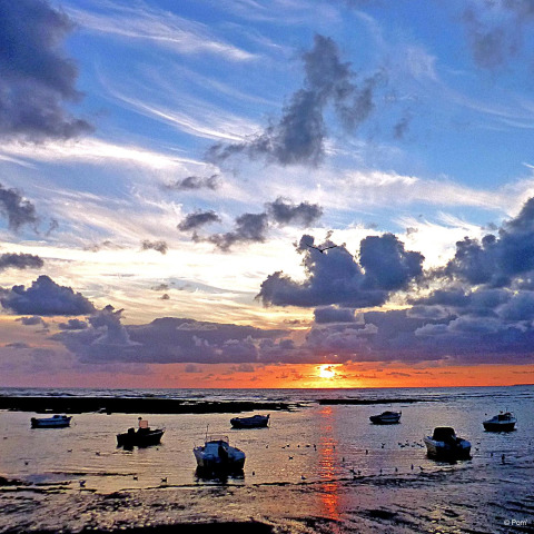 Boats anchored at sunset at Flower Camping Au Bois Des Biches holiday park in Pays de la Loire, France.