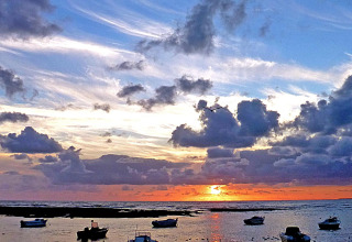 Boats anchored at sunset at Flower Camping Au Bois Des Biches holiday park in Pays de la Loire, France.