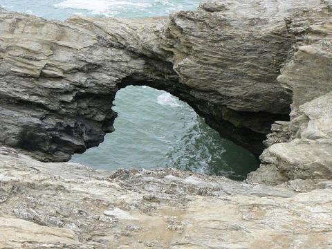 Fels mit natürlichem Bogen an der Küste nahe Saint Hilaire de Riez, Pays de la Loire, Frankreich über dem Meer.