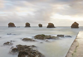 Rocky sea formations and misty water at Flower Camping Au Bois Des Biches holiday park, Pays de la Loire, France.