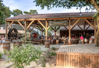 Espace repas en plein air du Flower Camping Au Bois Des Biches avec des vacanciers, à Pays de la Loire, France.