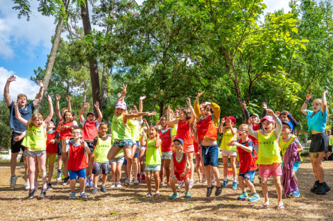 Enfants et adultes sautent et s’amusent en plein air au Flower Camping Au Bois Des Biches, Pays de la Loire.